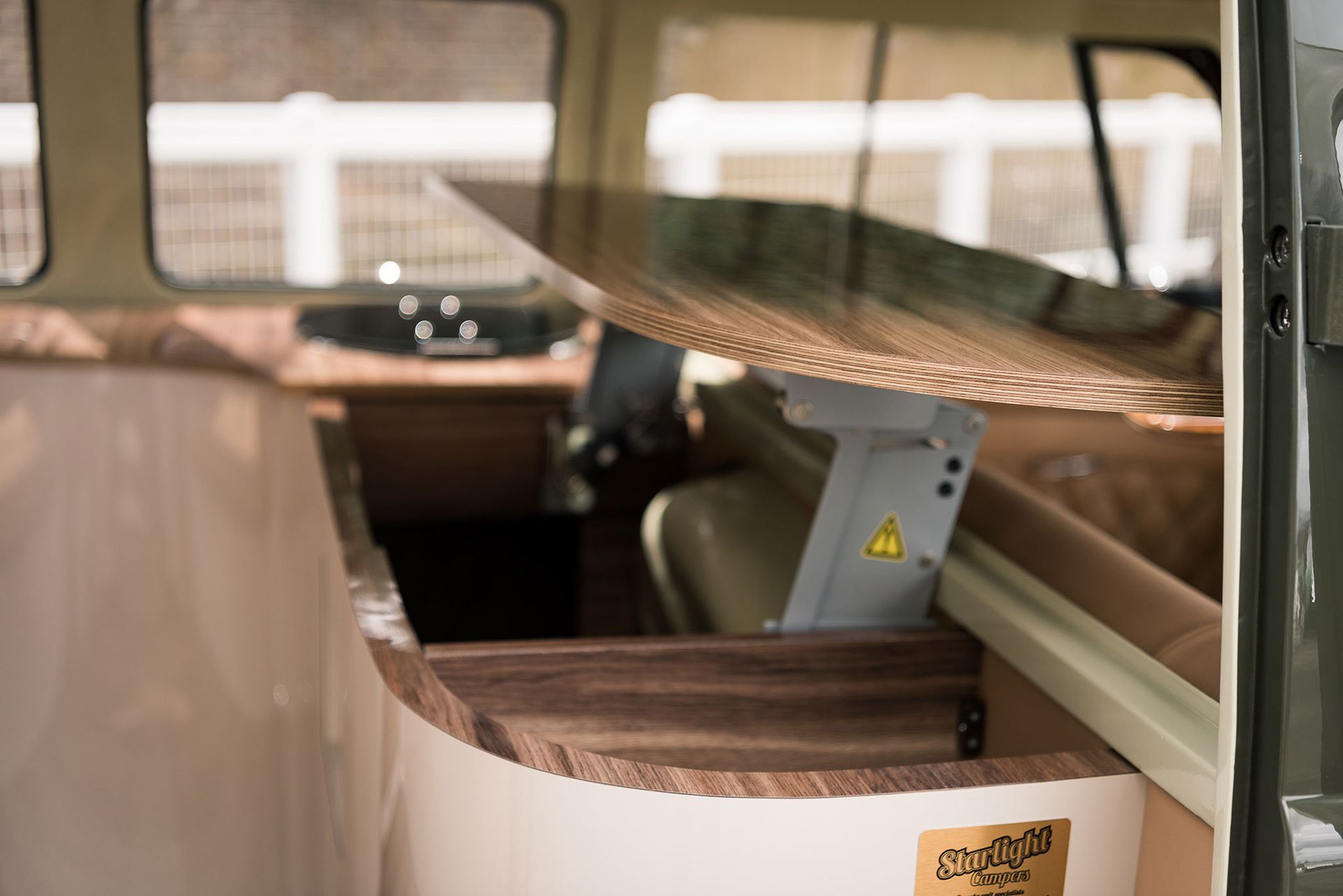 Interior of a vehicle with an open fold-down table or bunk and a warning symbol on the support bracket
