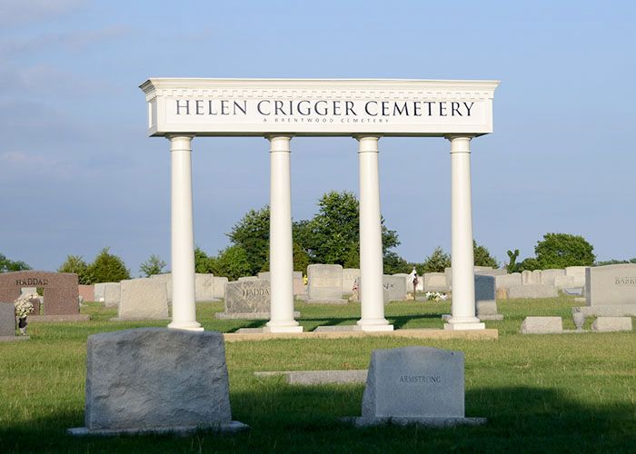 Helen Crigger Cemetery entrance sign with white columns and gravestones in the background
