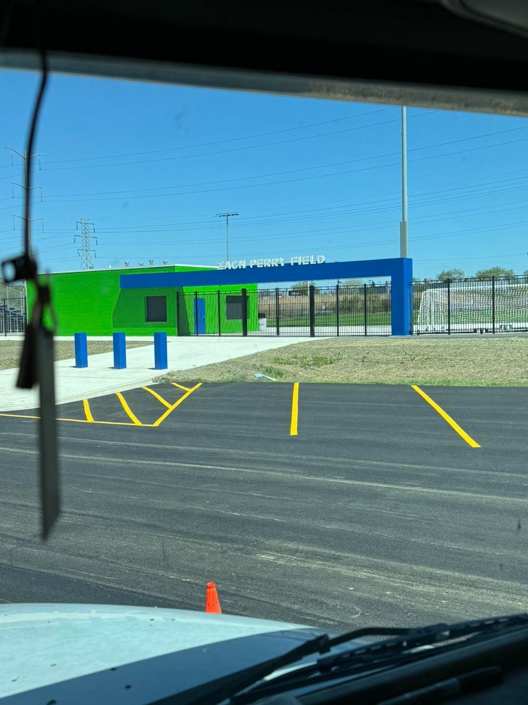 Colorful building beside empty parking lot, viewed from inside a vehicle.