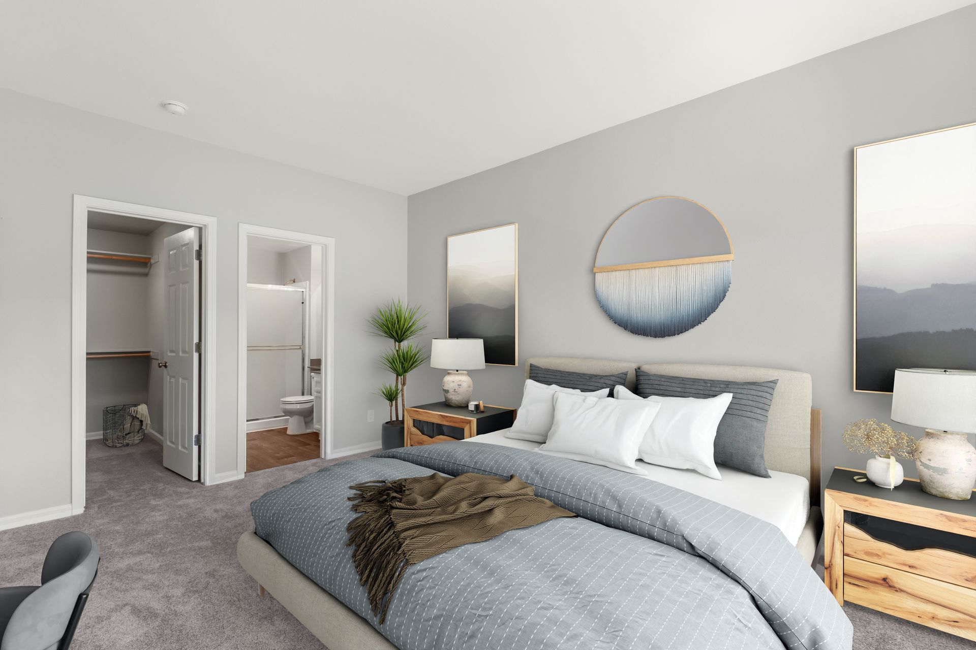 Primary bedroom with plush carpeting, a queen bed, bedside tables, walk-in closet, and en-suite bathroom.