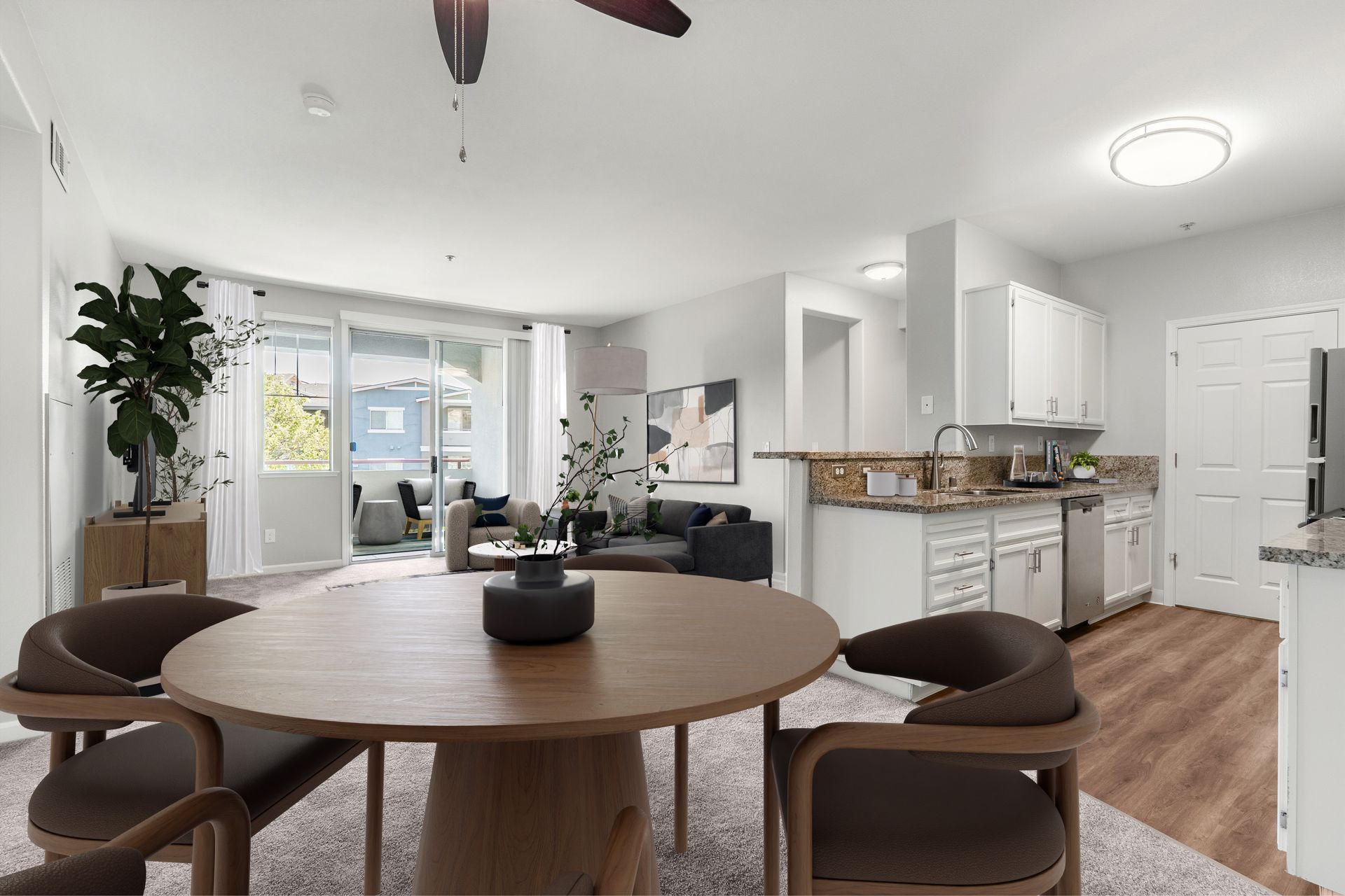 Open-concept apartment with a modern kitchen, dining area, living room, breakfast bar, and private balcony.