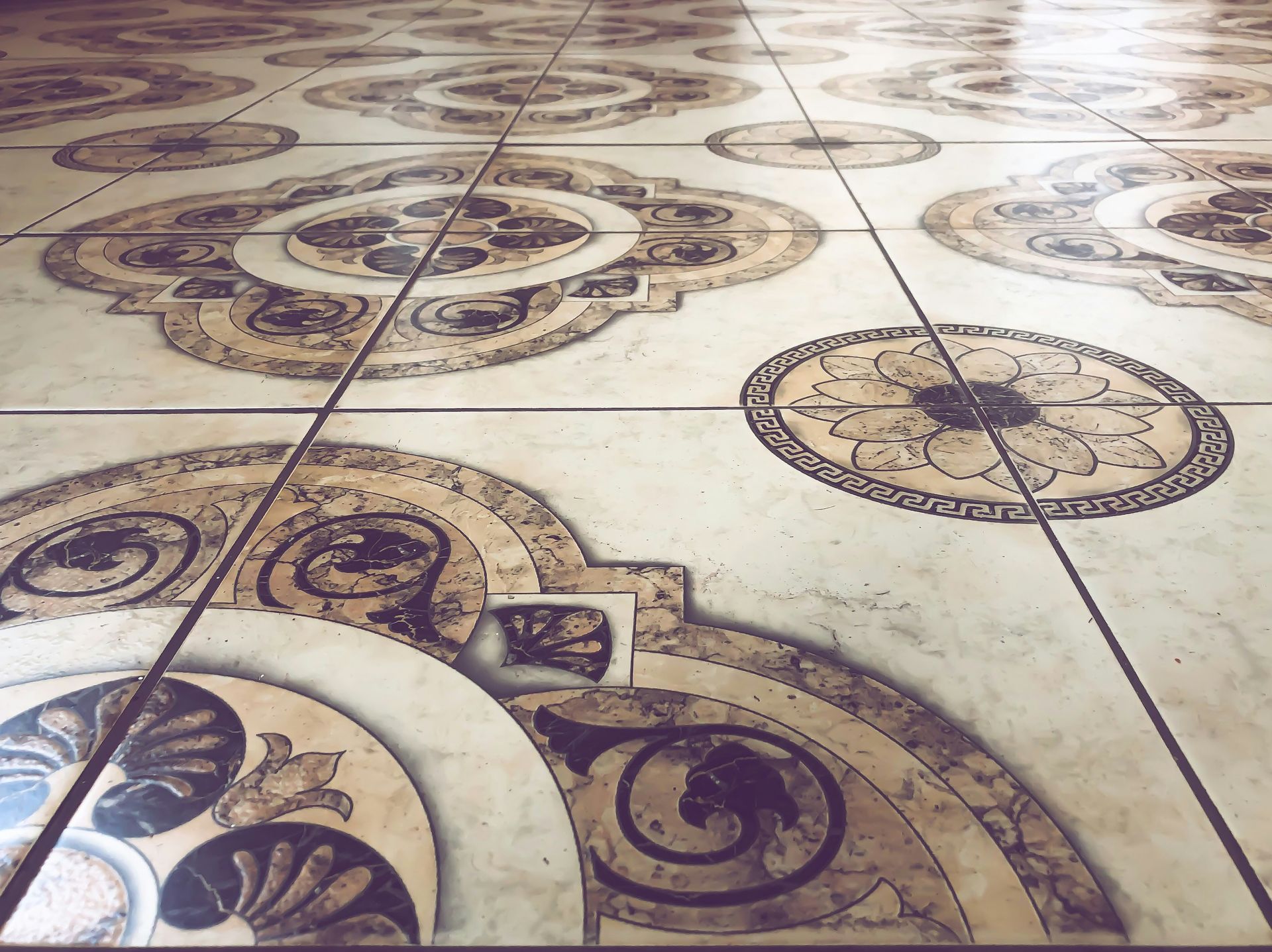 Decorative cream tile floor with intricate brown circular and floral patterns
