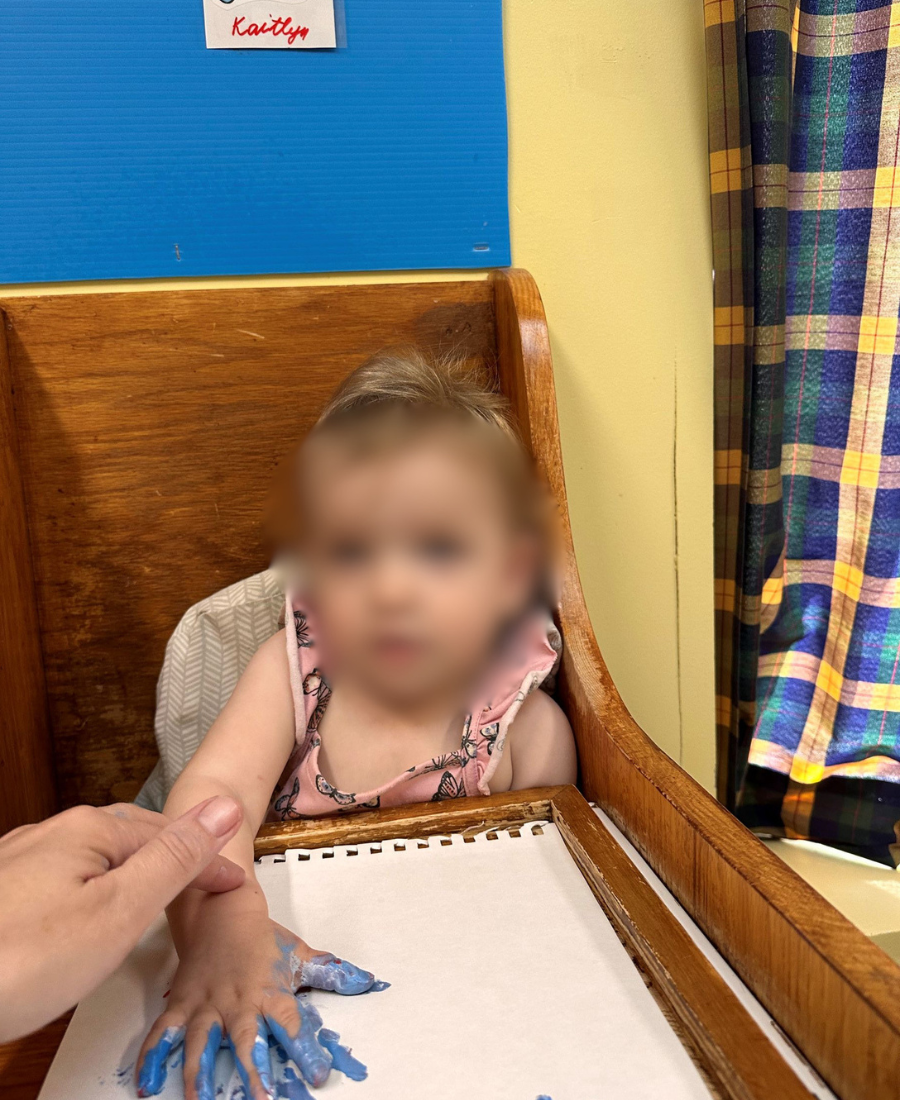 Bébé souriant lors d'une activité de peinture avec les doigts