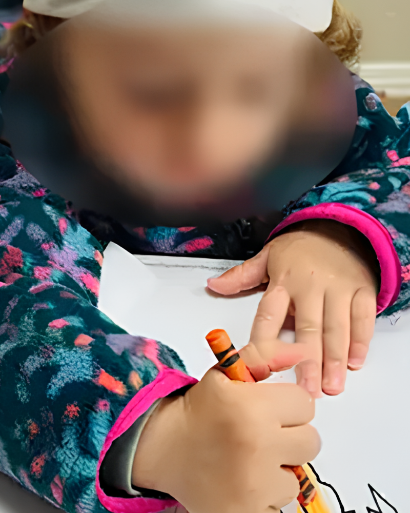 Enfant réalisant une activité créative guidée par une éducatrice