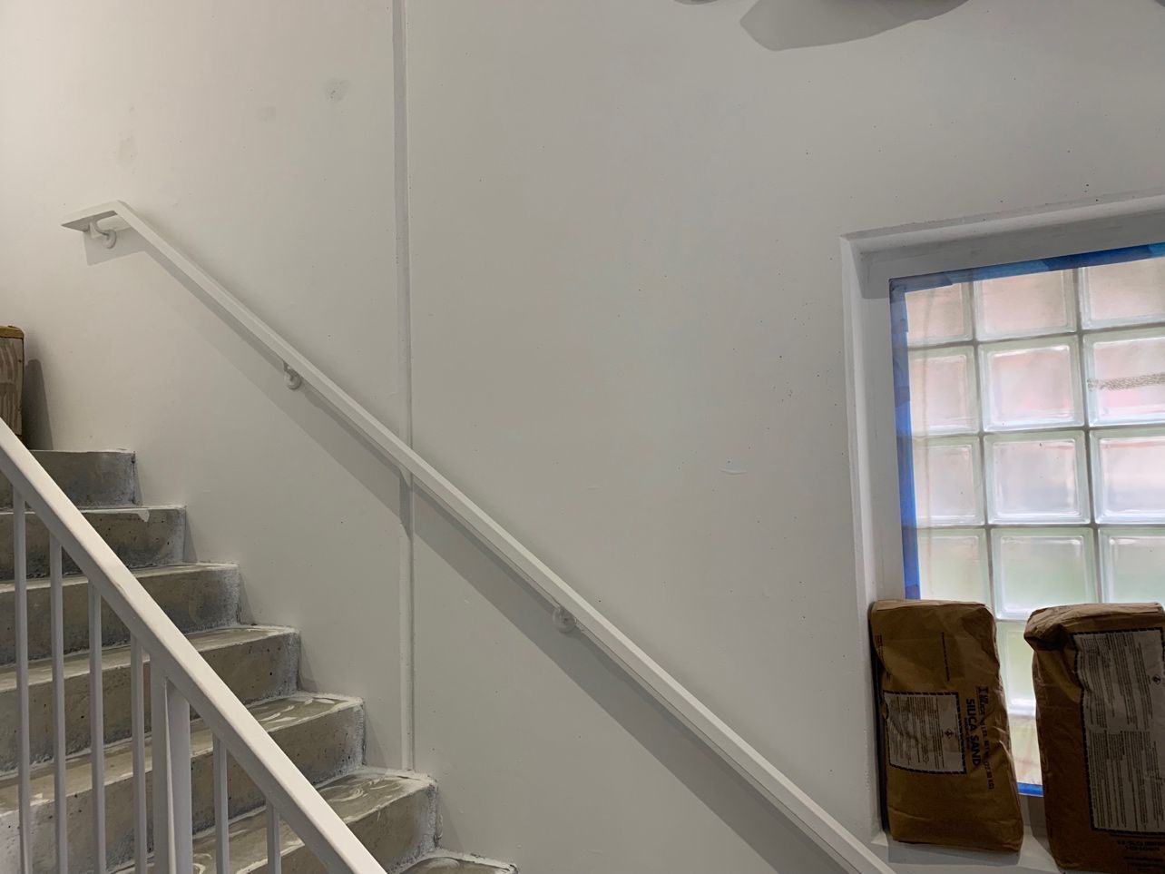 A staircase with a white railing and a window.