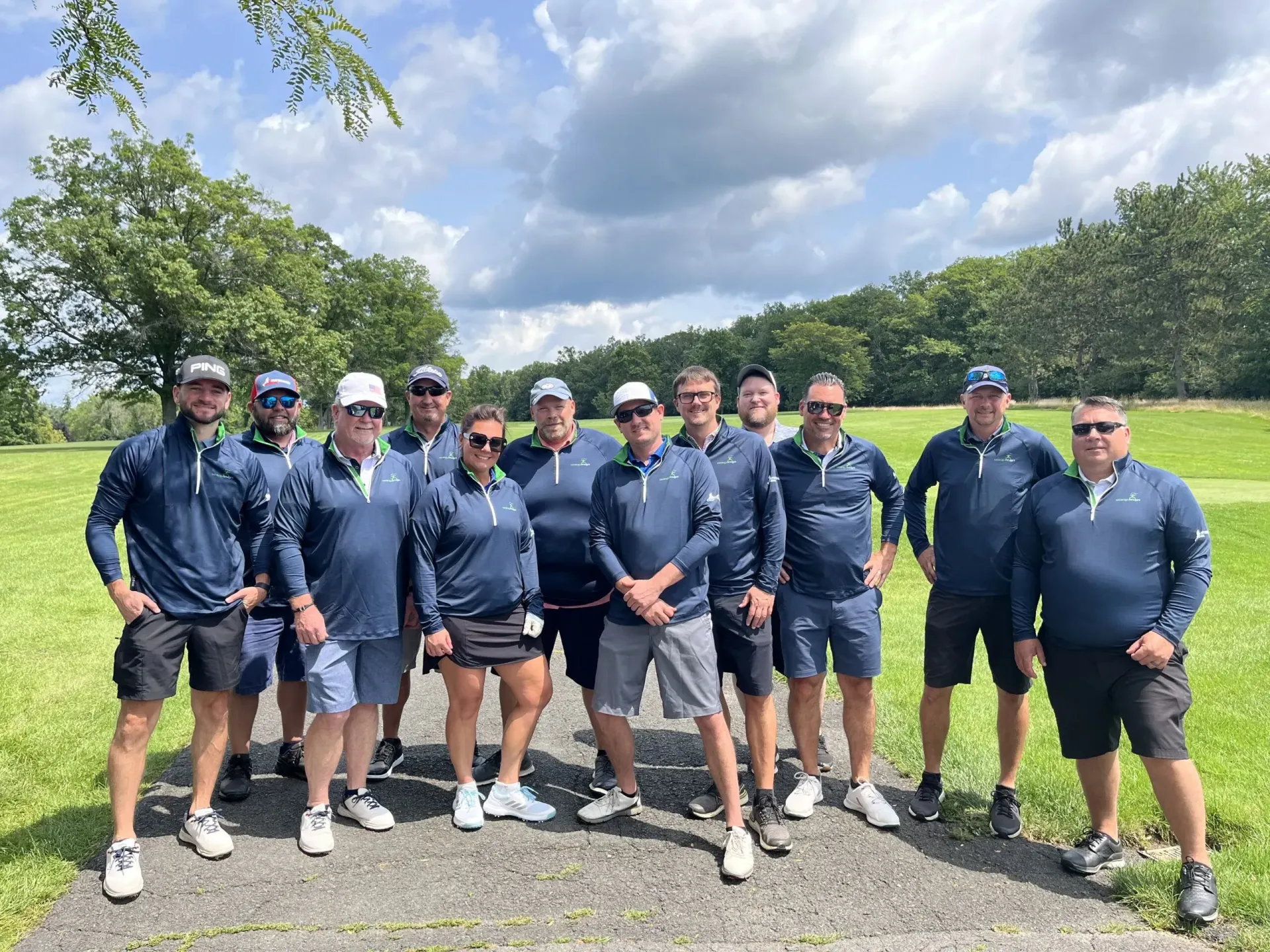 A group of people are posing for a picture on a golf course.