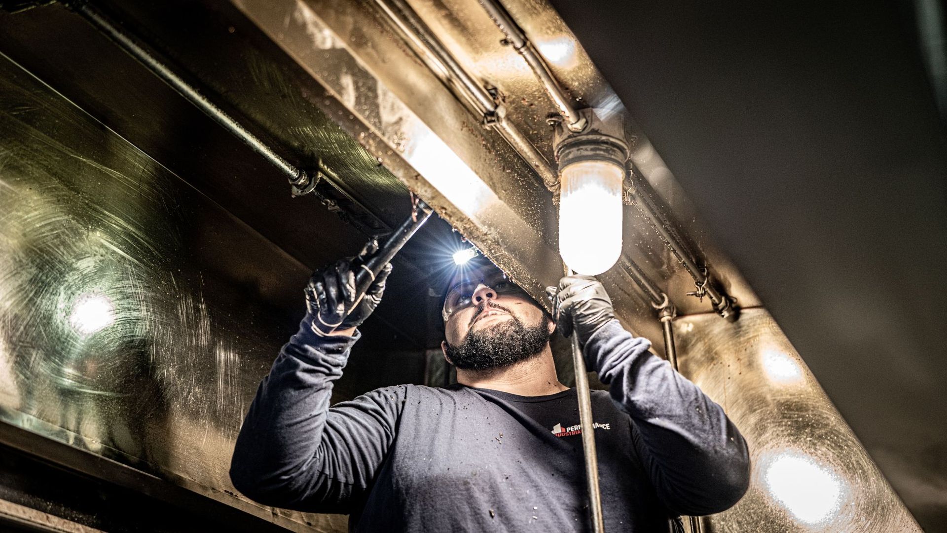 A Man Is Working on A Ceiling with A Flashlight | S. Glens Falls, NY | Performance Industrial