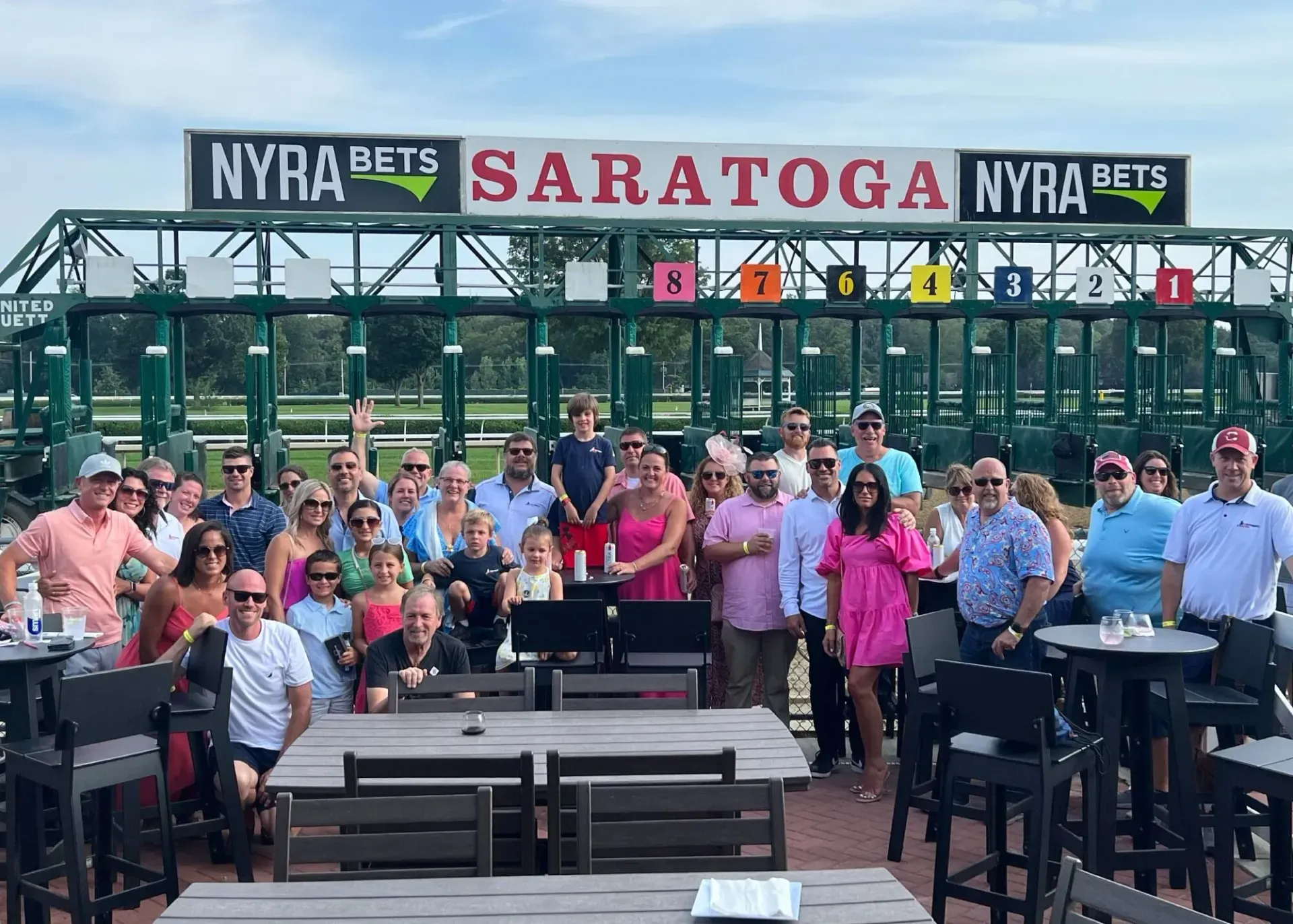 A group of people are posing for a picture in front of a race track.