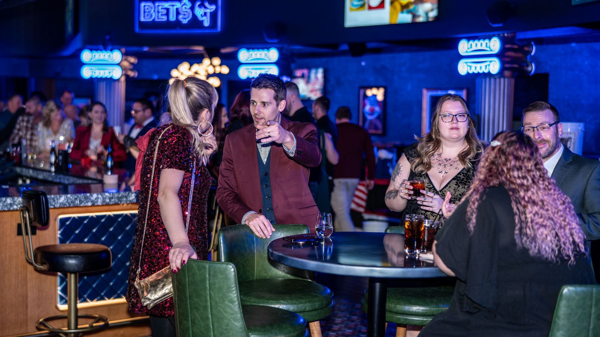  Performance Industrial team members gathered around a table with drinks, talking and laughing during the company’s annual employee appreciation event at a private venue.