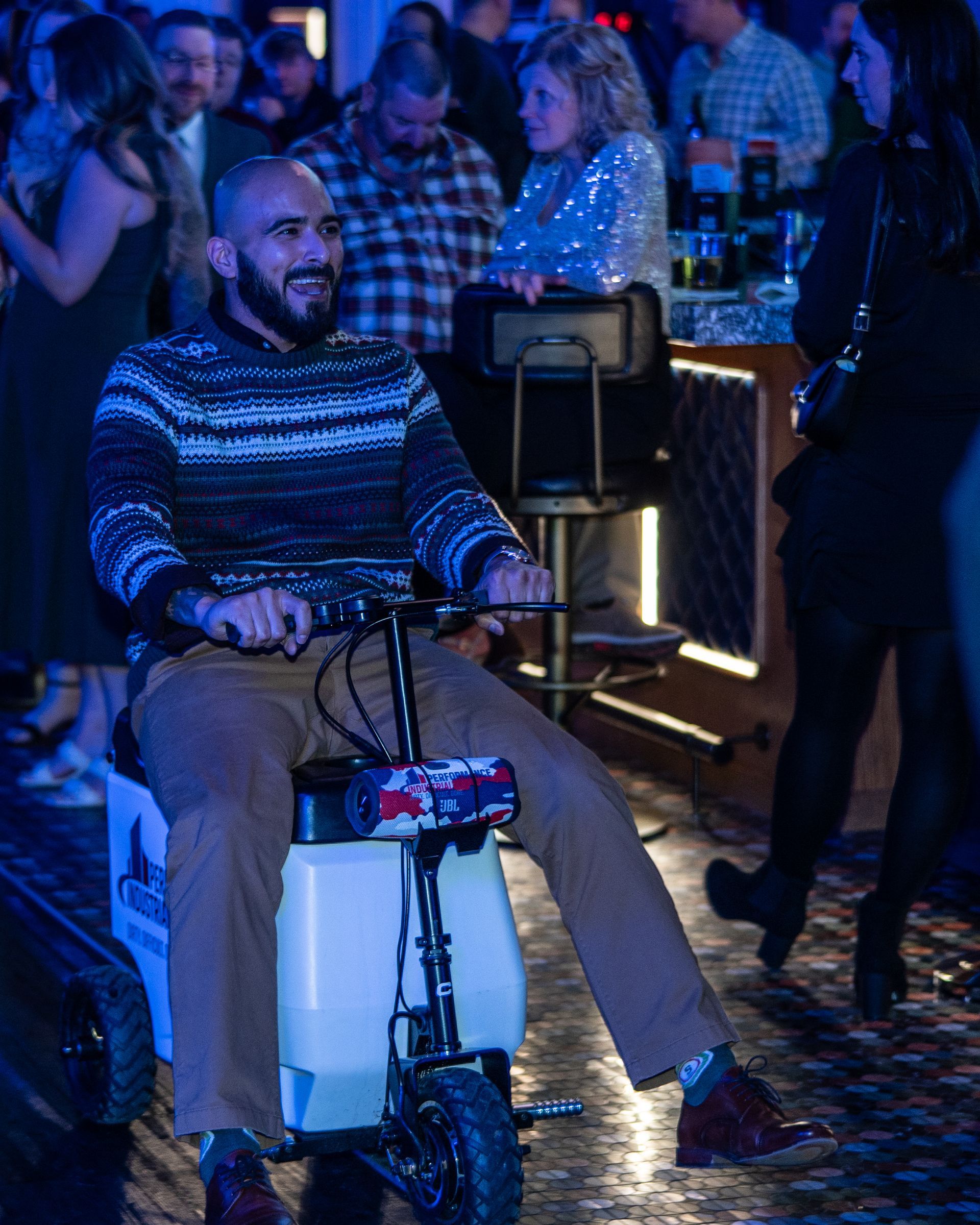  Employee riding a motorized cooler on wheels after winning it during Performance Industrial’s annual holiday party raffle.
