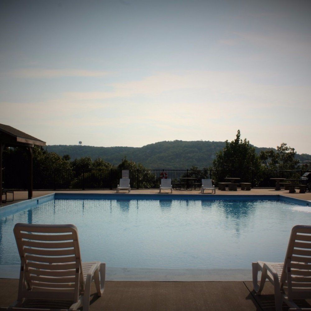 Quiet outdoor pool with lounge chairs overlooking distant hills at dusk