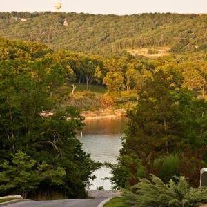 Wooded hills framing a calm river inlet at sunset