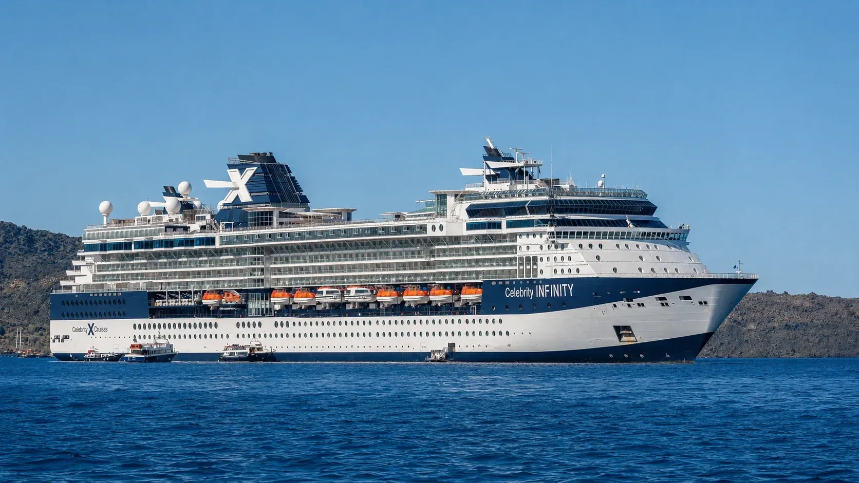 Celebrity Infinity cruise ship staying ashore at the Santorini caldera with tender boats bringing passengers ashore