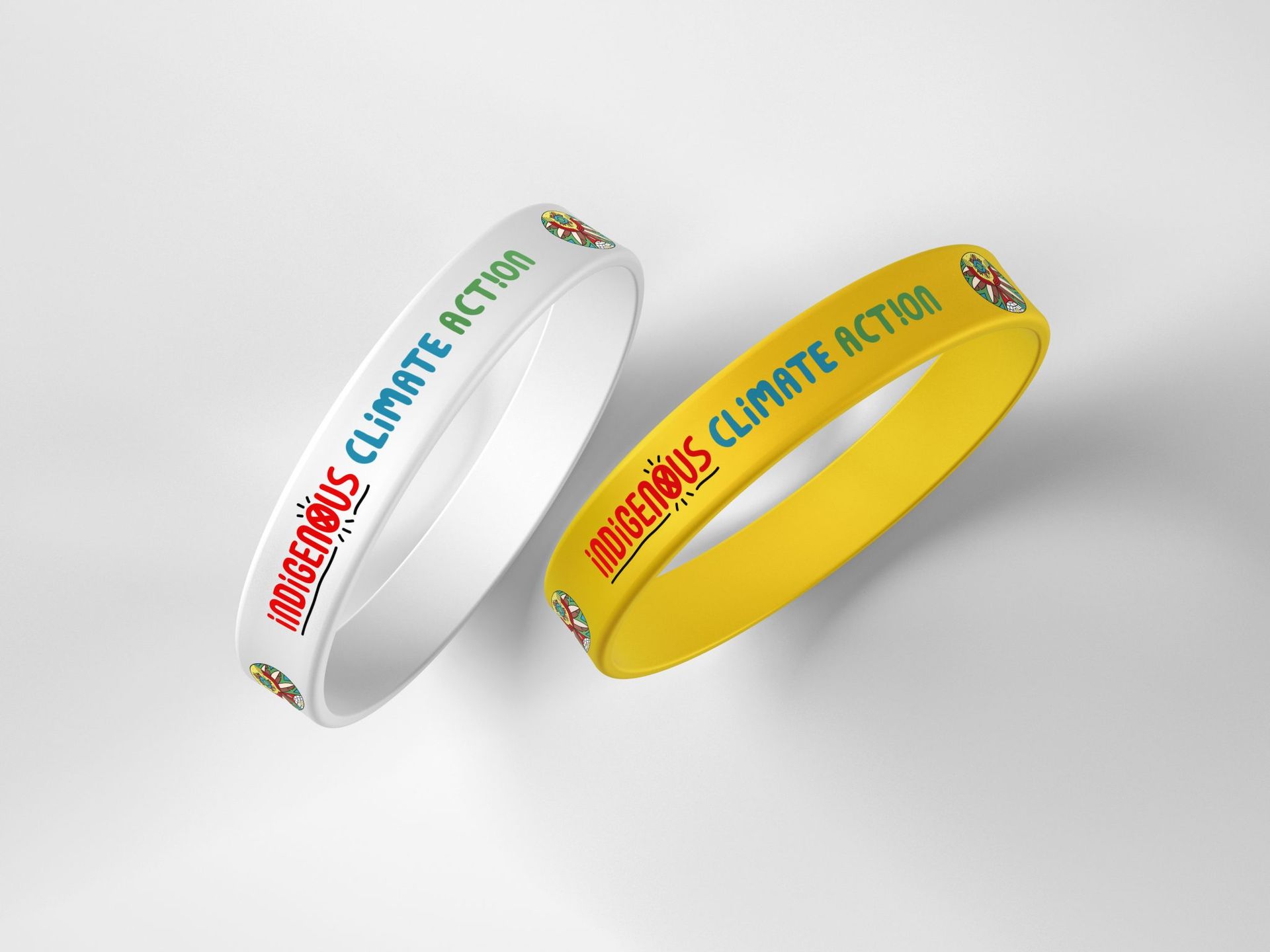Indigenous Climate Action promotional white and yellow silicone bracelets