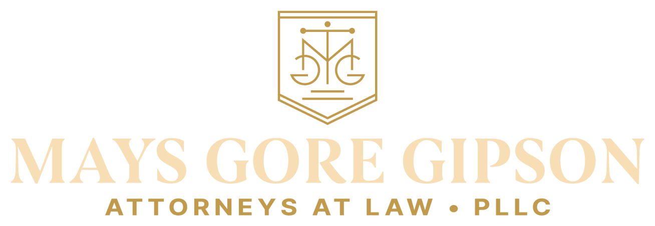 Logo for Mays Gore Gipson, Attorneys at Law, in gold. Features a shield with scales and letters.