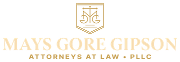 Logo for Mays Gore Gipson, Attorneys at Law, in gold. Features a shield with scales and letters.