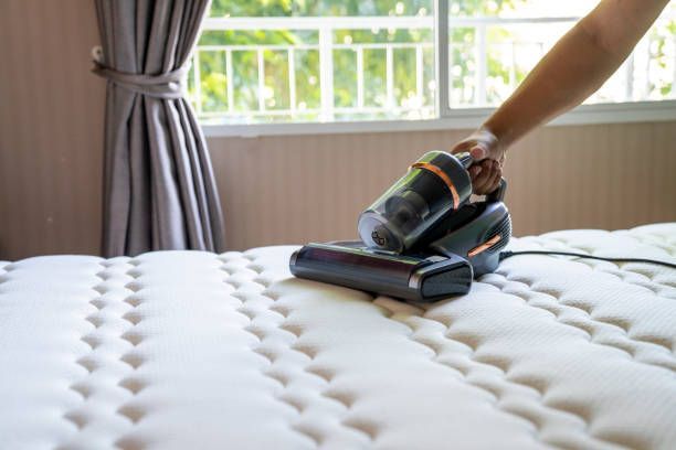 A Person is Cleaning a Mattress with a Vacuum Cleaner — Port O' Call Cleaning In Cannon Valley, QLD