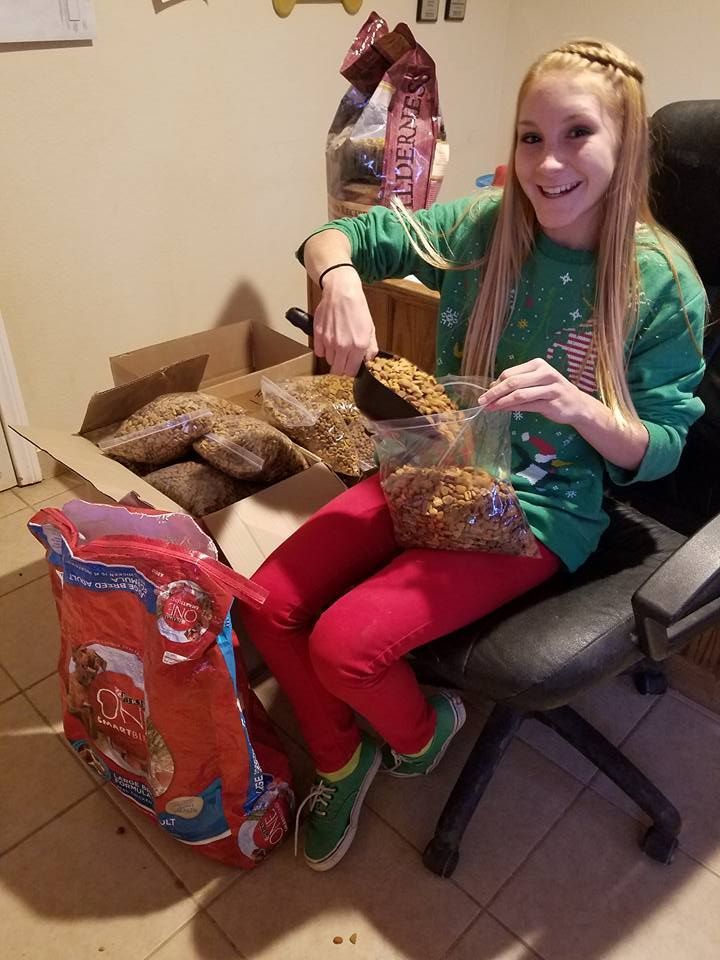 A young girl is sitting in a chair holding a bowl of cereal.