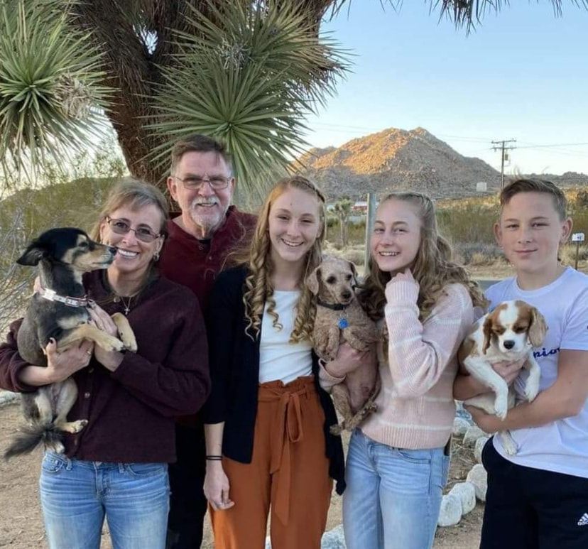 A family posing for a picture with their dogs