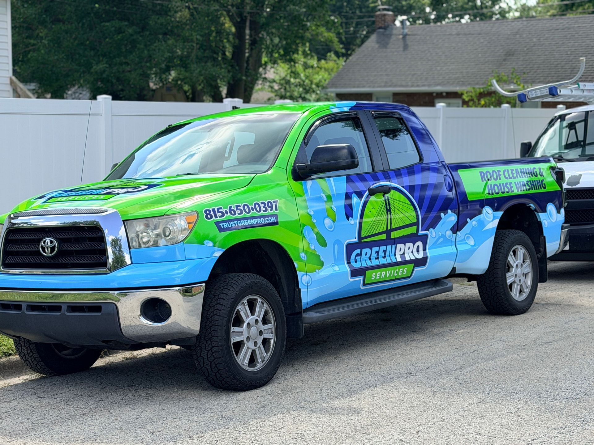 Rear window perforated vinyl on the new Green Pro Services work truck reading WE WASH HOUSES
