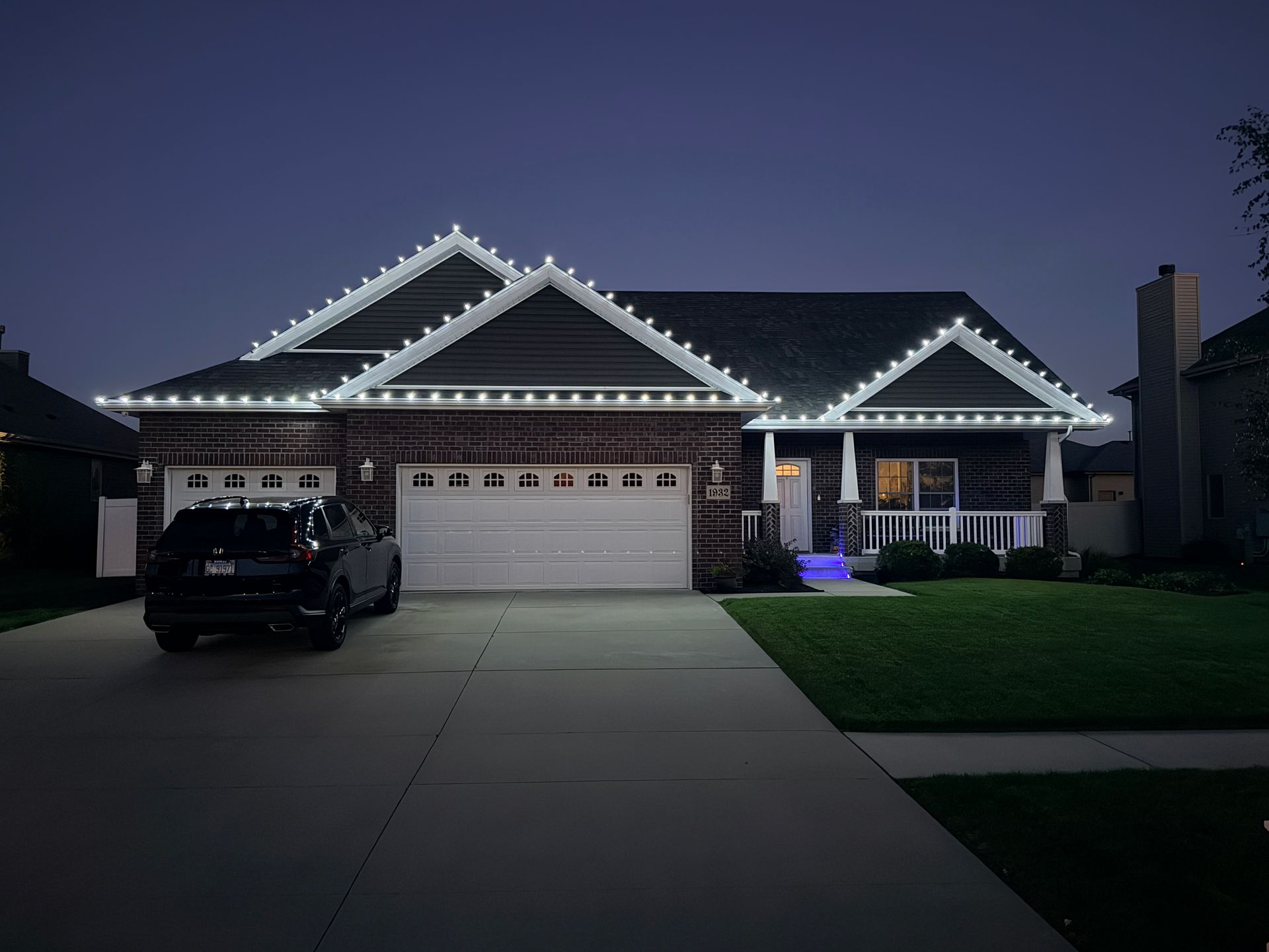 Cool white Christmas lights outlining a roofline, installed by Green Pro Services