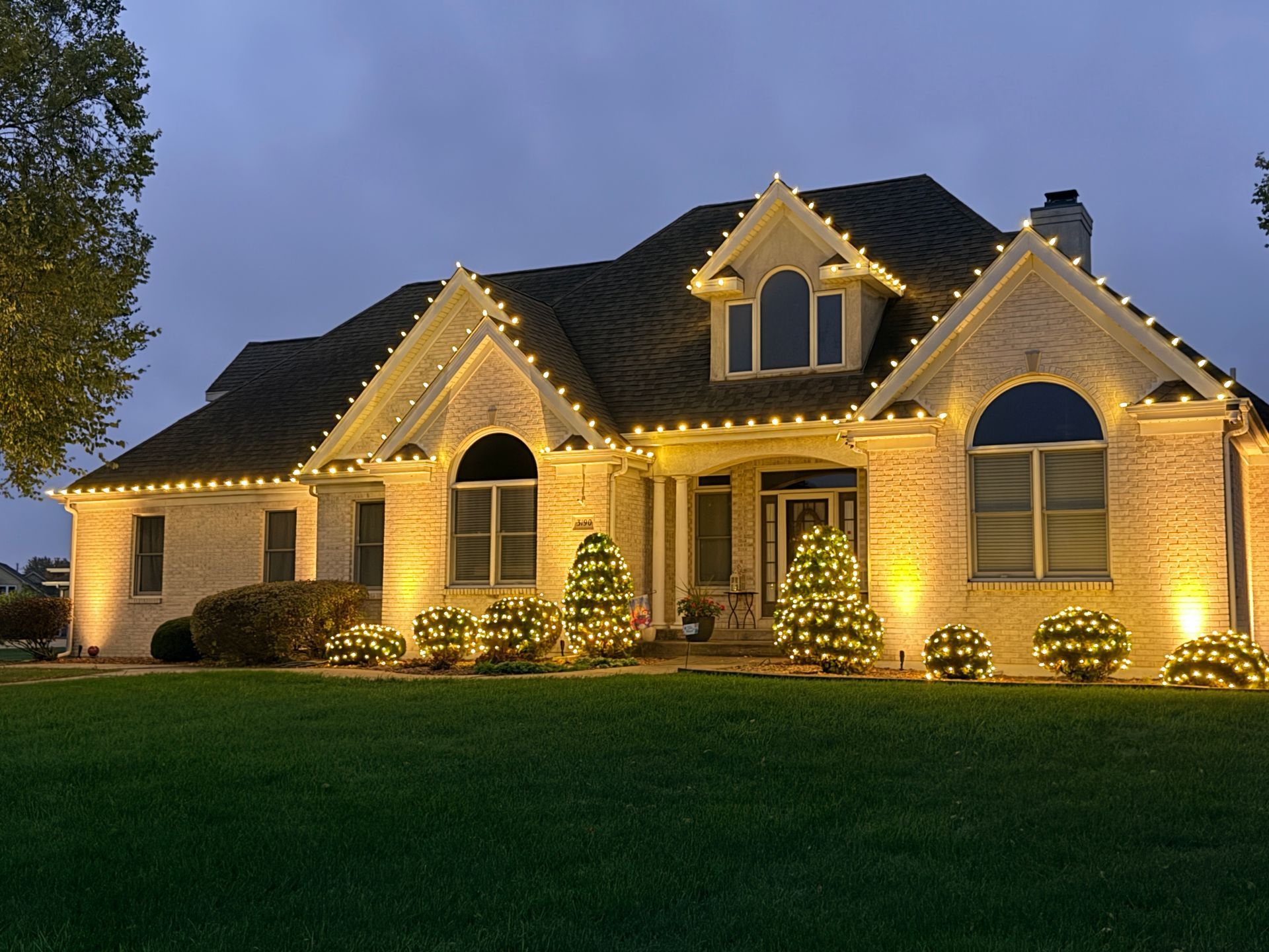 Warm white Christmas light installation on a home in Bourbonnais, Illinois by Green Pro Services