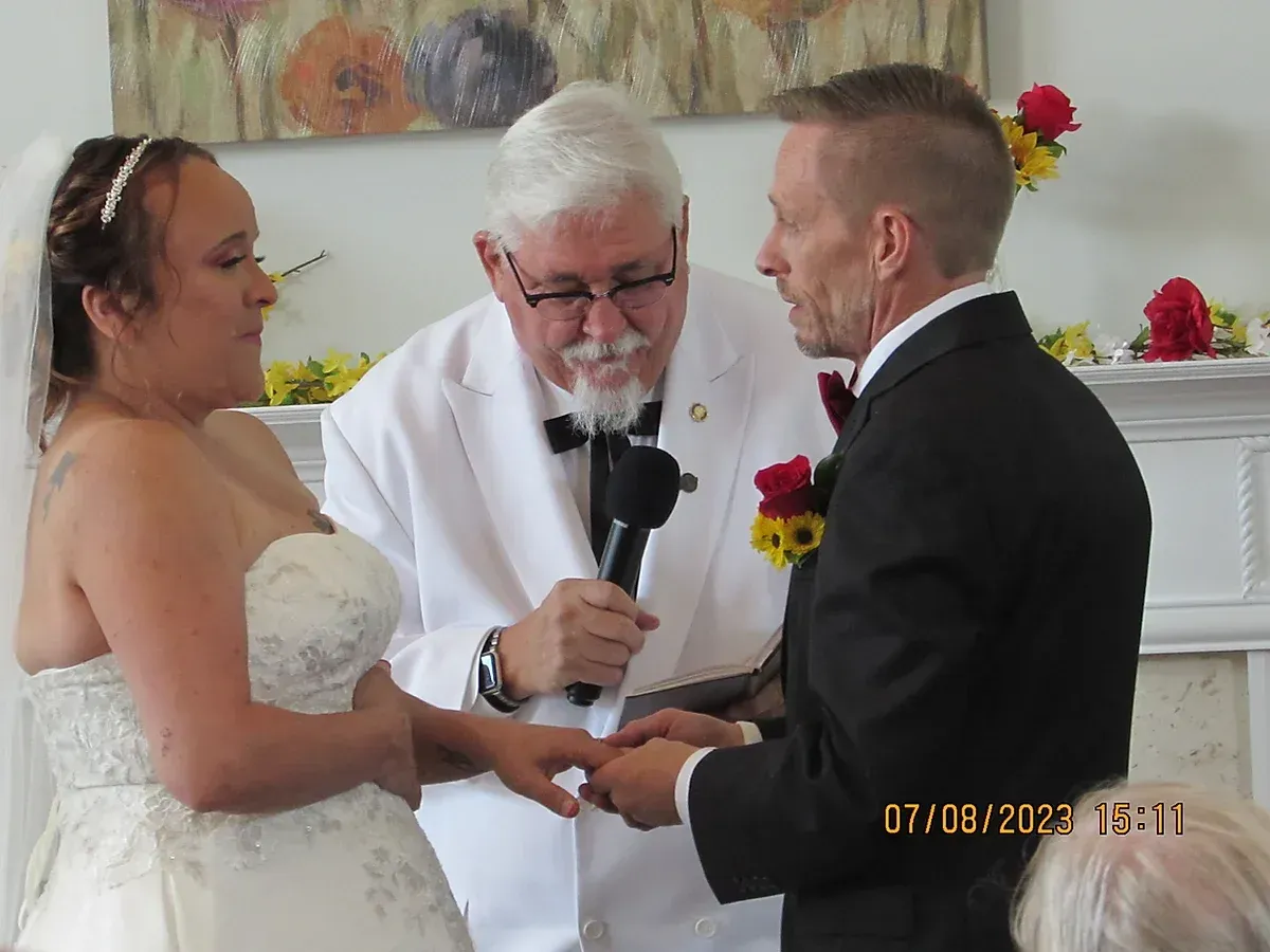 A man is putting a wedding ring on a bride 's finger