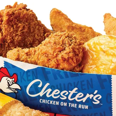 Crispy fried chicken pieces in a Chester’s takeout bag with logo and chicken mascot