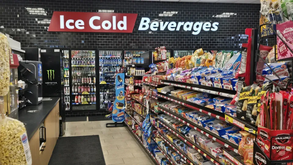 Convenience store beverage aisle with ice-cold drinks, snacks, and a refrigerated display at TA Janesville Travel Center