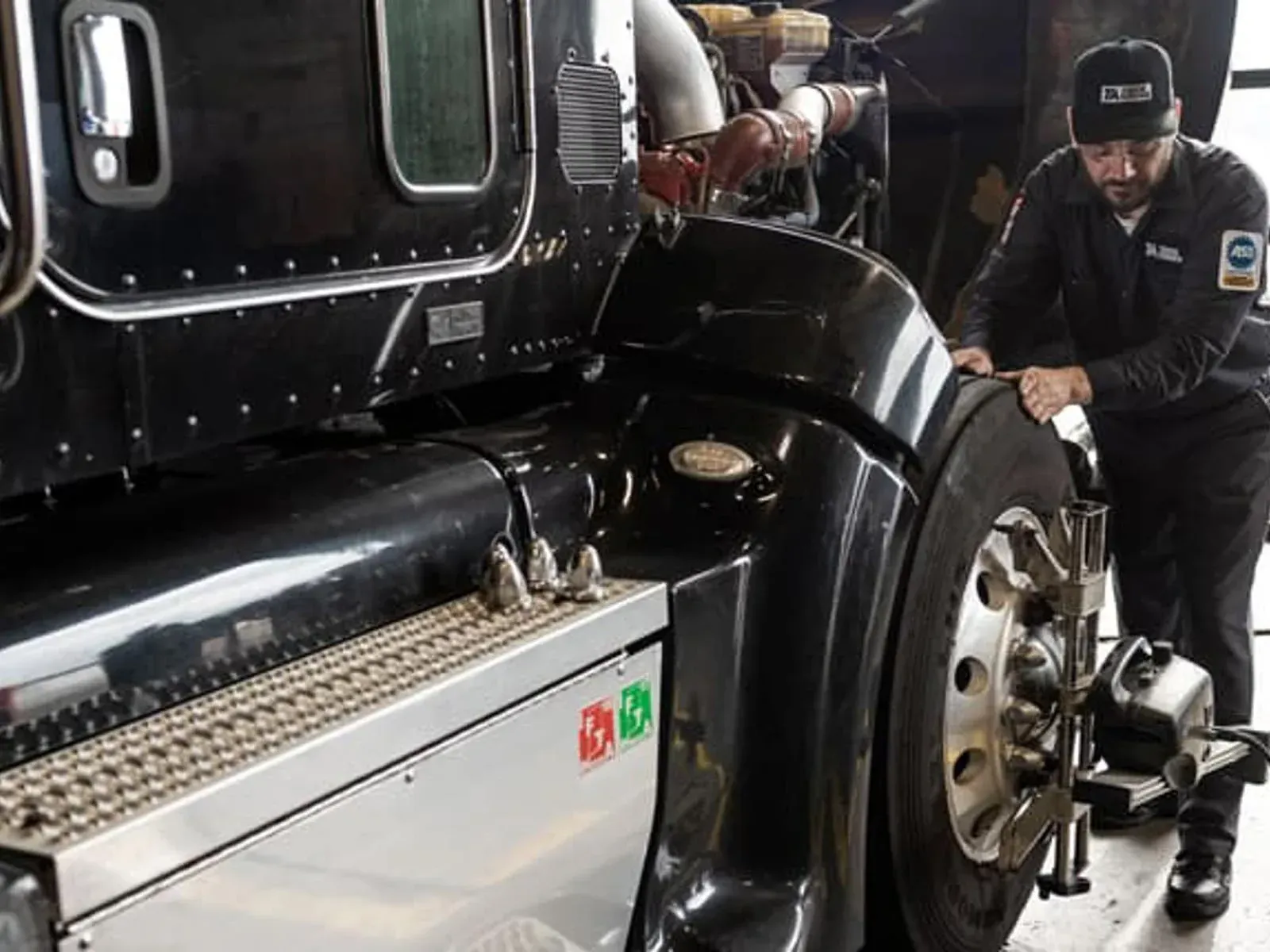 Diesel engine repair technician servicing a commercial semi-truck