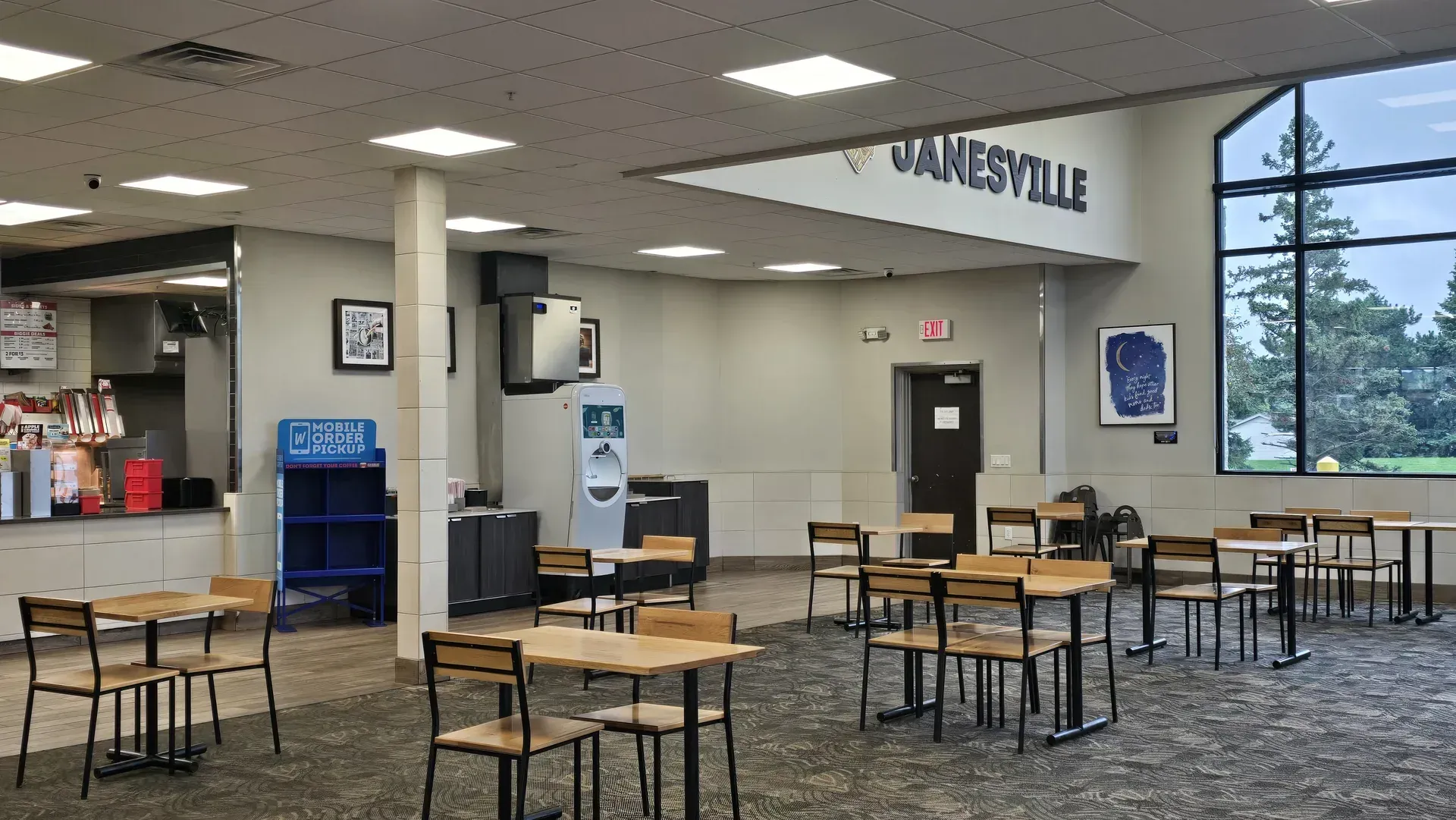 TA Janesville dining area with tables, vending machines, and a wall sign reading “JANESVILLE.”