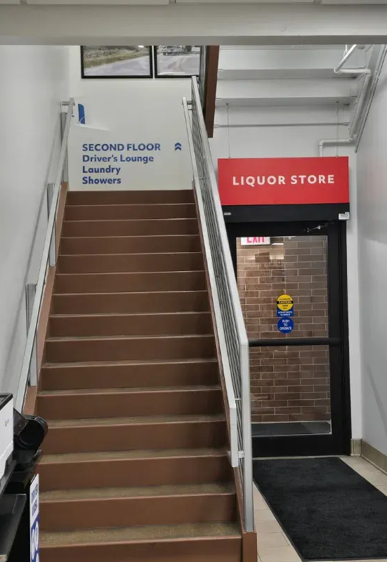 TA Janesville's inside liquor store entrance with a sign for Driver's Lounge on the second-floor laundry and restrooms