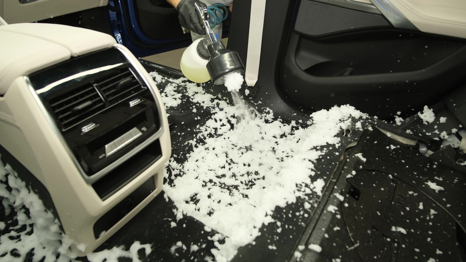 White foam spilled across a car’s black floor and center console area