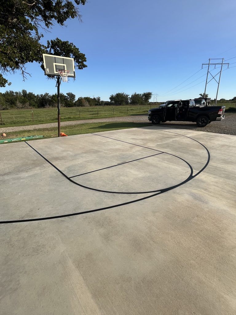 A basketball court with a truck parked in the background