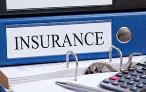Insurance binder with calculator and papers on a desk