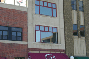 Building facades with red and beige brick, red-trimmed windows, and a purple storefront awning