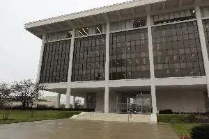 Modern building with a large glass facade and white columns on a cloudy day