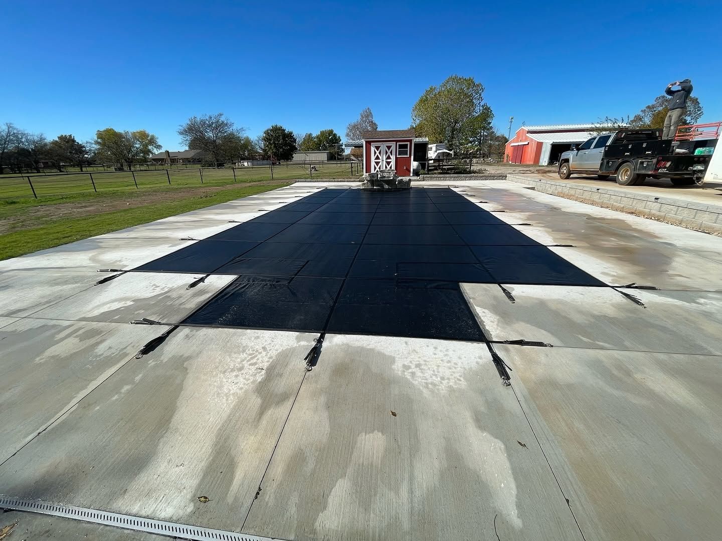 Paved road under construction with fresh dark asphalt and a building in the distance
