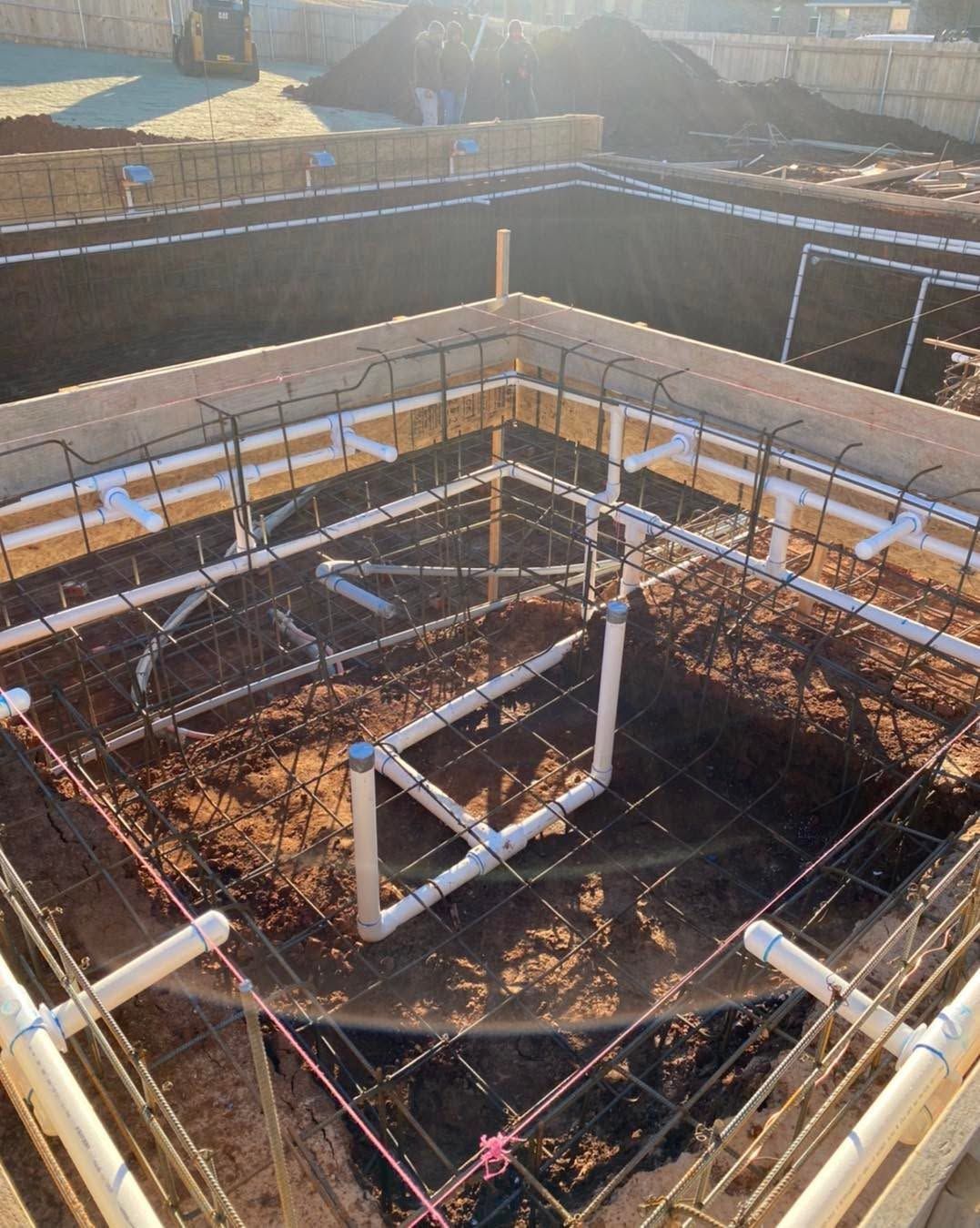 Rebar framework for a concrete foundation pit at a construction site, seen in sunlight