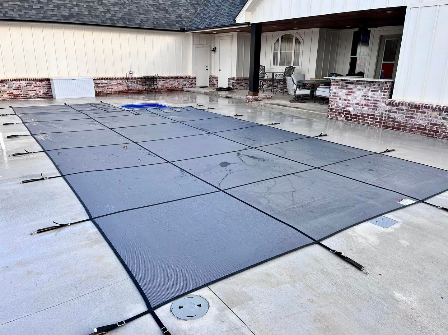 Covered pool patio with large dark gray floor panels and white building walls.