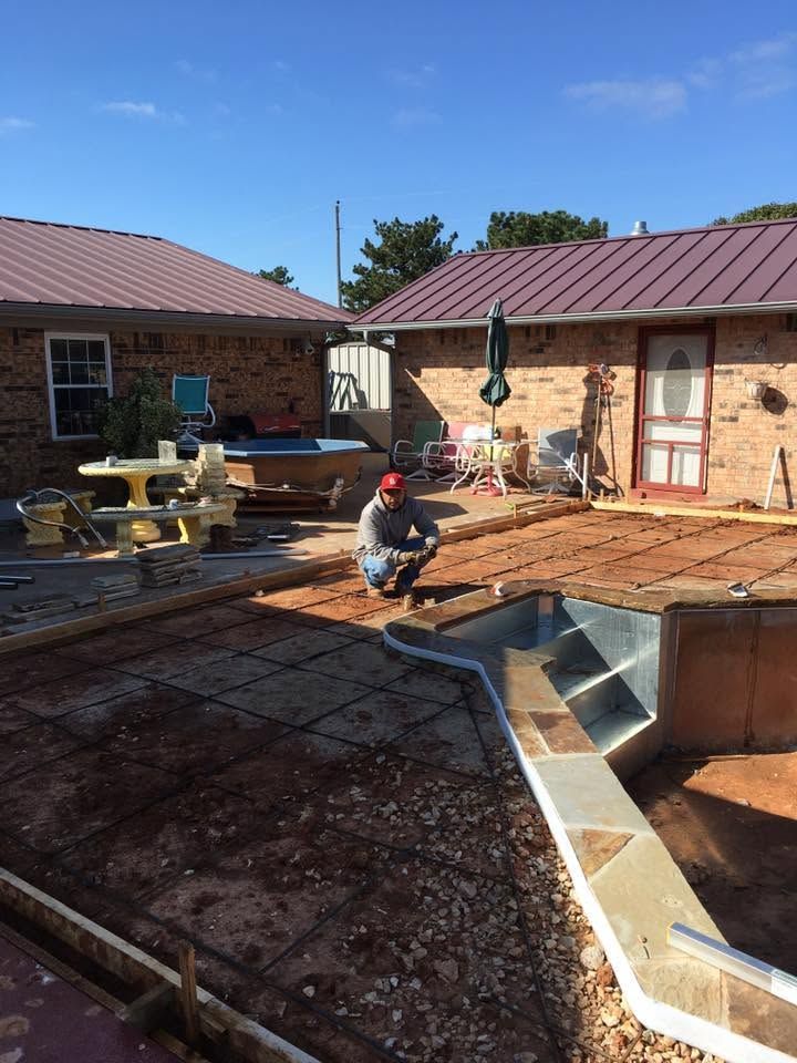 Worker laying paving stones in a brick courtyard between houses under construction