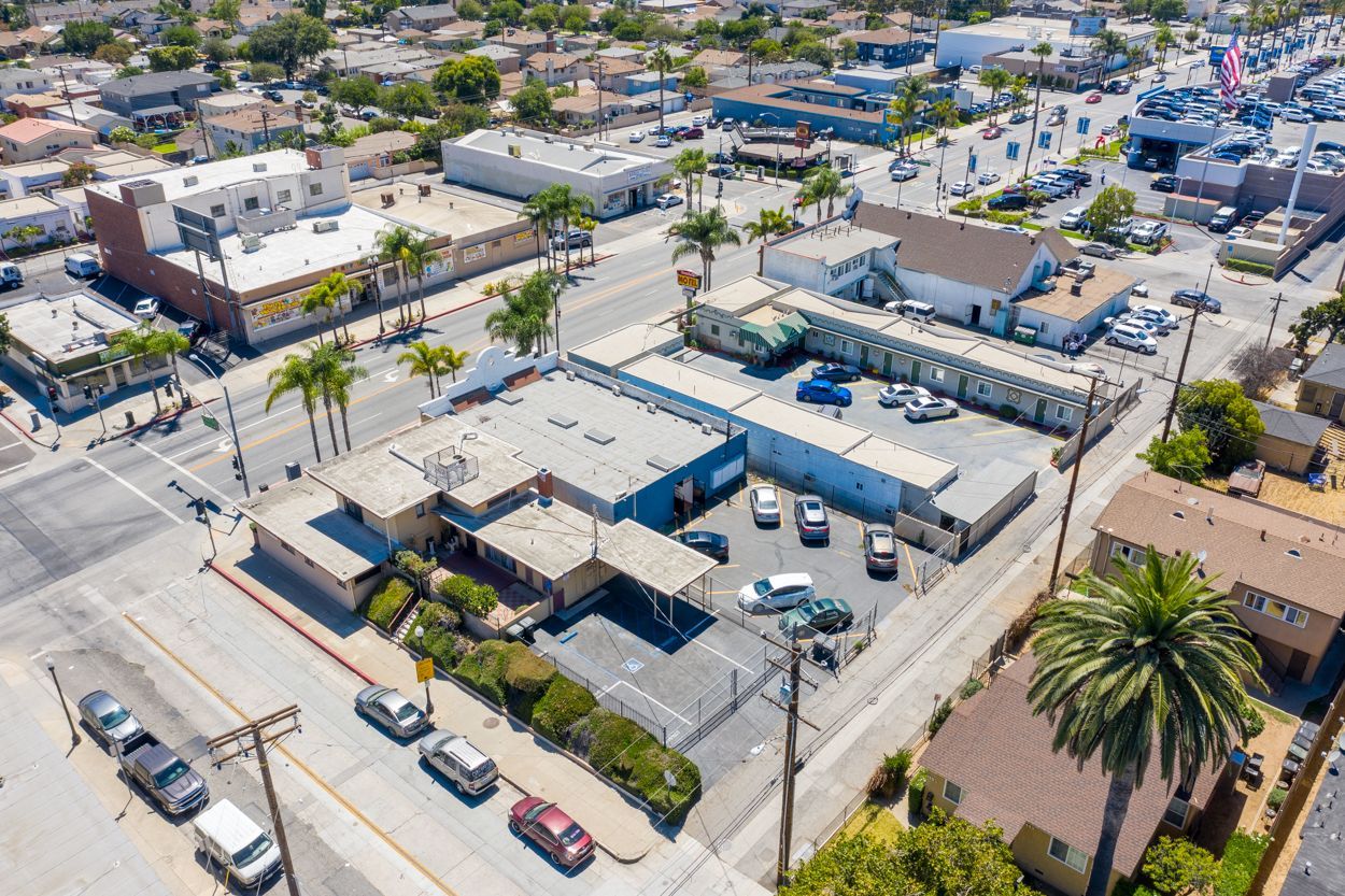An aerial view of a city with cars parked on the side of the road.