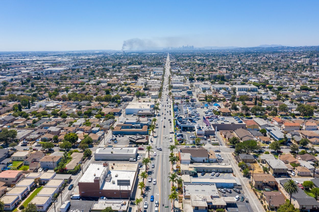 An aerial view of a city with a fire in the distance.