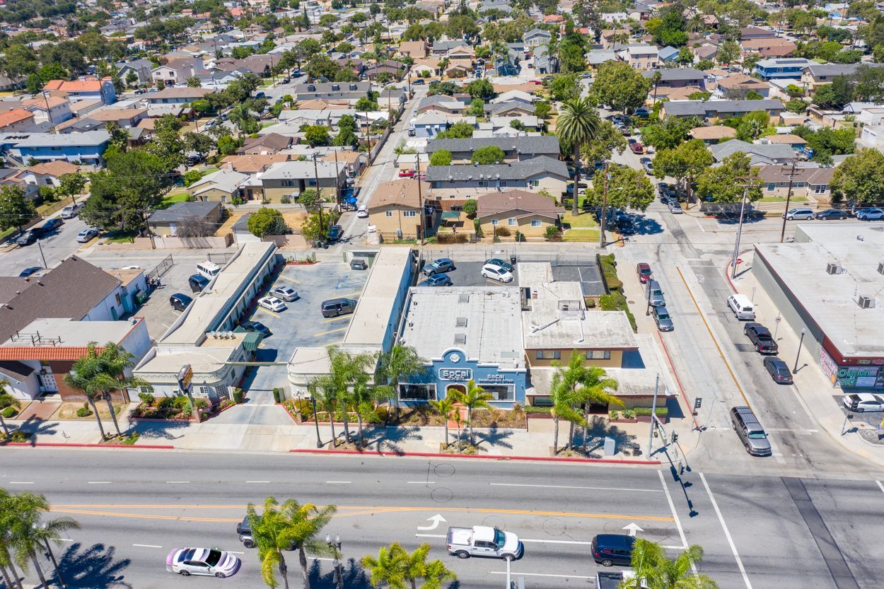 An aerial view of a city with a lot of buildings and cars on the road.