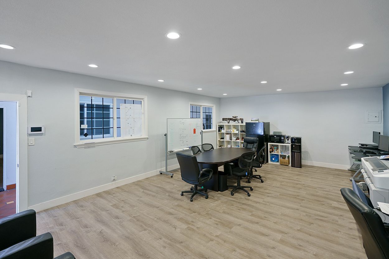 A large room with a table and chairs in it.