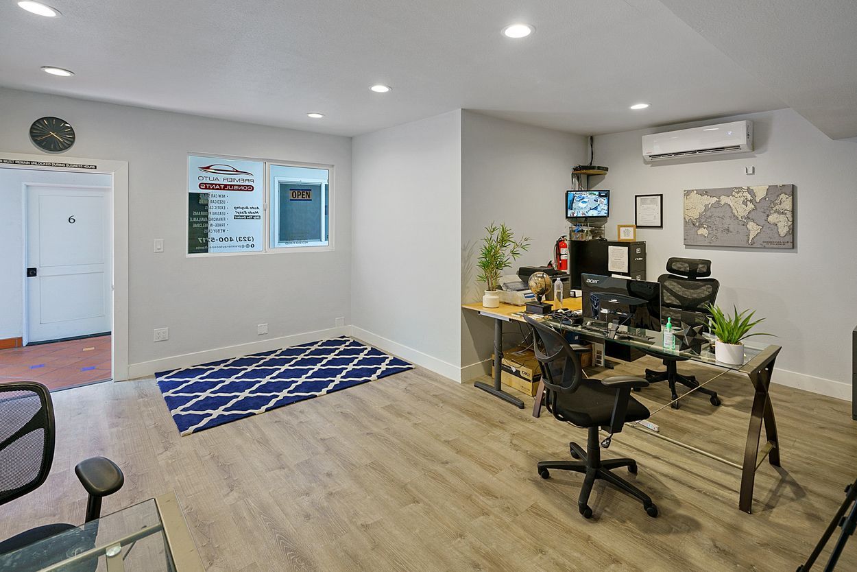 A room with a desk and chairs in it.