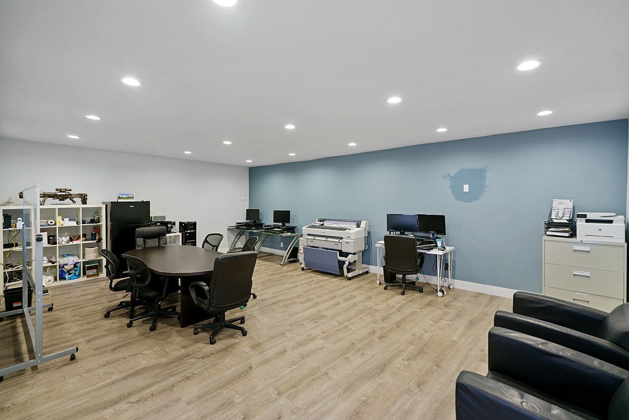 A large room with a table and chairs in it.