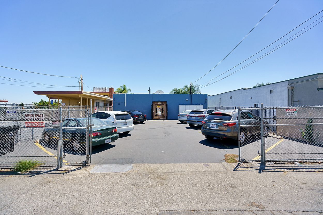 A parking lot with cars parked in front of a building.