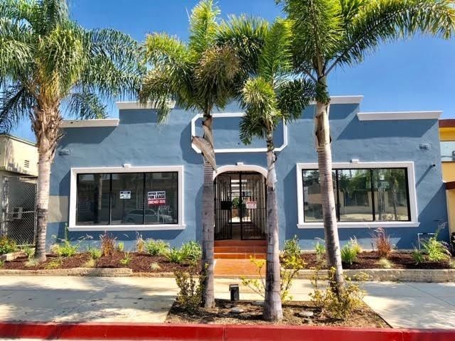 A blue building with palm trees in front of it