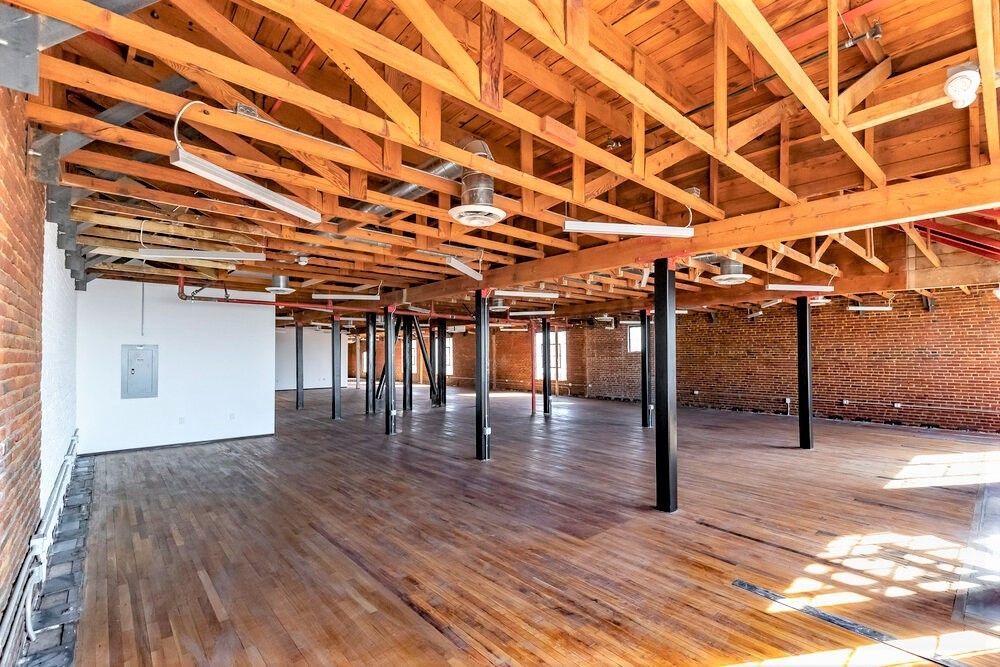 A large empty room with wooden floors and a wooden ceiling.